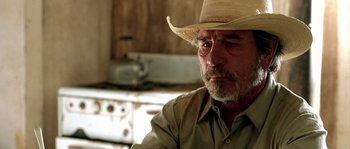 Movie still from “The Three Burials of Melquiades Estrada” (2005), directed by Tommy Lee Jones – An older man wearing a straw cowboy hat; Close Up shot, Over the shoulder angle
