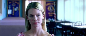 Movie still from “The Three Burials of Melquiades Estrada” (2005), directed by Tommy Lee Jones – A woman with blonde hair and blue eye shadow; Close Up shot, Over the shoulder angle