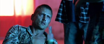 Movie still from “The Three Burials of Melquiades Estrada” (2005), directed by Tommy Lee Jones – A man holding a bottle of alcohol in his hand; Close Up shot, Low angle