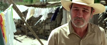 Movie still from “The Three Burials of Melquiades Estrada” (2005), directed by Tommy Lee Jones – An older man wearing a cowboy hat near clothes line; Close Up shot, Low angle