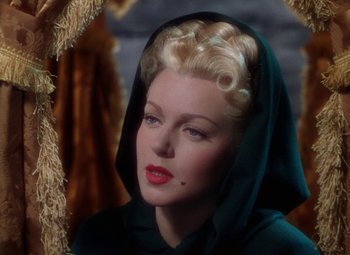 A woman with blonde ringlets wearing a black veil