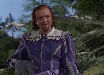 Movie still from “The Three Musketeers” (1948), directed by George Sidney – A person wearing a suit and tie; Medium shot, Over the shoulder angle