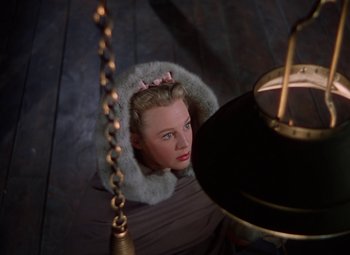 Movie still from “The Three Musketeers” (1948), directed by George Sidney – A woman in a fur coat looking up at the ceiling; Medium shot, High angle