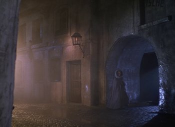 Movie still from “The Three Musketeers” (1948), directed by George Sidney – A woman in a long dress standing in front of a building; Wide shot, High angle