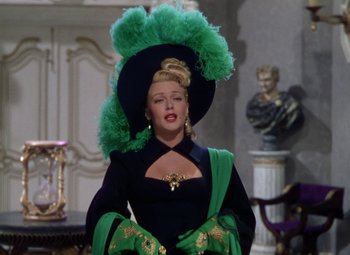 Movie still from “The Three Musketeers” (1948), directed by George Sidney – A woman wearing a green hat and a black dress; Medium shot, Over the shoulder angle