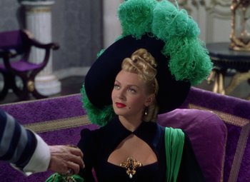 Movie still from “The Three Musketeers” (1948), directed by George Sidney – A woman wearing a green hat and a black dress; Medium shot, Over the shoulder angle