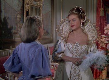 Movie still from “The Three Musketeers” (1948), directed by George Sidney – A woman in a white dress talking to another woman in a blue dress; Medium shot, Over the shoulder angle