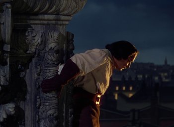Movie still from “The Three Musketeers” (1948), directed by George Sidney – A man leaning against a pillar on a balcony; Medium shot, Low angle