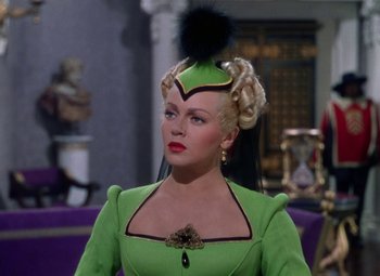 Movie still from “The Three Musketeers” (1948), directed by George Sidney – A woman in a lime green dress with a black hat; Close Up shot, Over the shoulder angle