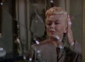 Movie still from “The Three Musketeers” (1948), directed by George Sidney – A woman with blonde hair is standing in front of a mirror; Close Up shot, Over the shoulder angle