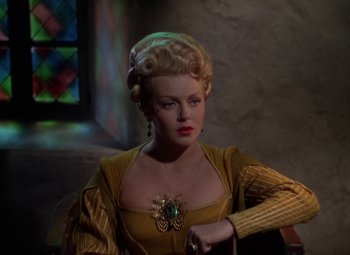 Movie still from “The Three Musketeers” (1948), directed by George Sidney – A woman with blonde hair and a yellow dress; Medium shot, Over the shoulder angle