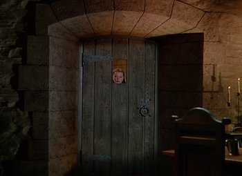 Movie still from “The Three Musketeers” (1948), directed by George Sidney – A woman peeking out from behind a wooden door; Wide shot, High angle