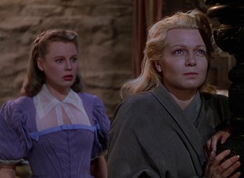 Movie still from “The Three Musketeers” (1948), directed by George Sidney – Two women standing next to each other in front of a brick wall; Medium shot, Low angle