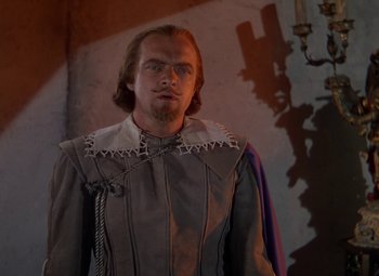 Movie still from “The Three Musketeers” (1948), directed by George Sidney – A man in a medieval outfit standing in a room; Medium shot, Low angle