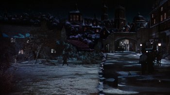 Movie still from “The Time Machine” (1960), directed by George Pal – A snowy night scene of a town with a bridge and buildings; Extreme Wide shot, High angle