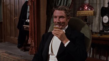 Movie still from “The Time Machine” (1960), directed by George Pal – A man sitting in a chair holding a glass of beer; Medium shot, Over the shoulder angle