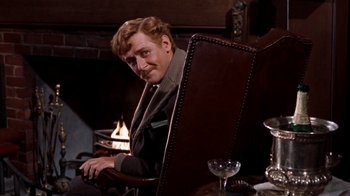 Movie still from “The Time Machine” (1960), directed by George Pal – A man sitting at a table in front of a fireplace; Medium shot, Over the shoulder angle