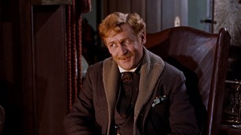 Movie still from “The Time Machine” (1960), directed by George Pal – A person sitting in a chair wearing a suit; Close Up shot, Over the shoulder angle