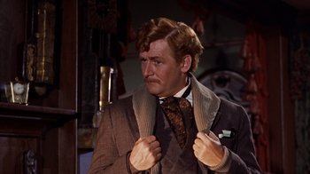 Movie still from “The Time Machine” (1960), directed by George Pal – A man in a suit and tie holding his jacket; Close Up shot, Low angle