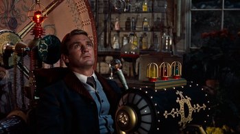 Movie still from “The Time Machine” (1960), directed by George Pal – A man sitting in front of an old fashioned machine; Medium shot, Low angle