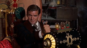 Movie still from “The Time Machine” (1960), directed by George Pal – A man in a suit and tie holding a key; Medium shot, Low angle