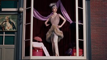 Movie still from “The Time Machine” (1960), directed by George Pal – A woman standing in front of a window wearing a dress; Wide shot, Low angle