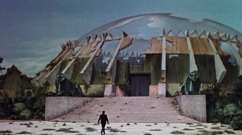 Movie still from “The Time Machine” (1960), directed by George Pal – A man walking down the steps in front of a building; Extreme Wide shot, Low angle