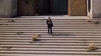 Movie still from “The Time Machine” (1960), directed by George Pal – A man in a business suit standing on some steps; Extreme Wide shot, High angle