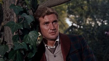Movie still from “The Time Machine” (1960), directed by George Pal – A person near a tree wearing a jacket; Close Up shot, Low angle