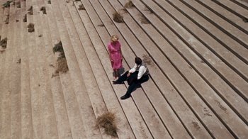 Movie still from “The Time Machine” (1960), directed by George Pal – A man and a woman sitting on a set of steps; Extreme Wide shot, Overhead angle