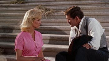 Movie still from “The Time Machine” (1960), directed by George Pal – A man and a woman sitting next to each other on steps; Medium shot, Over the shoulder angle