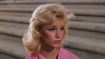 Movie still from “The Time Machine” (1960), directed by George Pal – A woman with blonde hair wearing a pink shirt; Close Up shot, Low angle