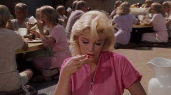 Movie still from “The Time Machine” (1960), directed by George Pal – A woman in a pink shirt is eating a snack; Medium shot, Over the shoulder angle