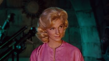 Movie still from “The Time Machine” (1960), directed by George Pal – A woman with blonde hair wearing a pink shirt; Close Up shot, Low angle