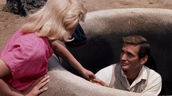 Movie still from “The Time Machine” (1960), directed by George Pal – A man and a woman are in a pool of water; Medium shot, High angle