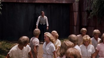 Movie still from “The Time Machine” (1960), directed by George Pal – A group of people standing in front of a building; Wide shot, High angle