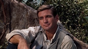 Movie still from “The Time Machine” (1960), directed by George Pal – A person sitting on a tree trunk; Close Up shot, Low angle