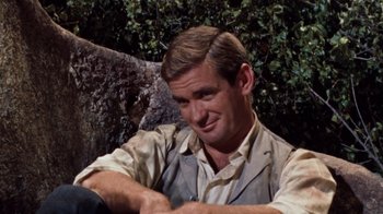 Movie still from “The Time Machine” (1960), directed by George Pal – A person sitting on the ground near a tree; Close Up shot, Over the shoulder angle