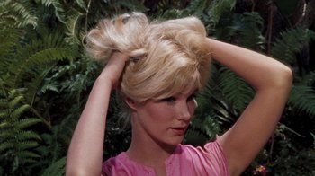 Movie still from “The Time Machine” (1960), directed by George Pal – A woman with blonde hair holding her hair in a bun; Close Up shot, High angle