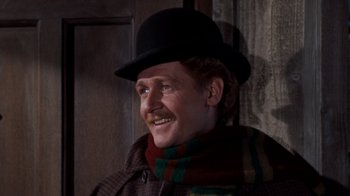 Movie still from “The Time Machine” (1960), directed by George Pal – A man wearing a black hat and a scarf; Close Up shot, Low angle