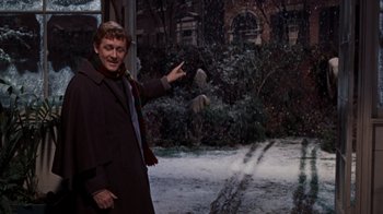 Movie still from “The Time Machine” (1960), directed by George Pal – A man in a brown coat pointing to the ground; Medium shot, Over the shoulder angle