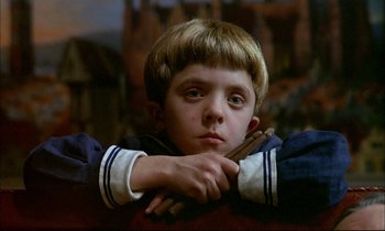 Movie still from “The Tin Drum” (1979), directed by Volker Schlöndorff – A young boy is holding a stick in his hand; Close Up shot, High angle