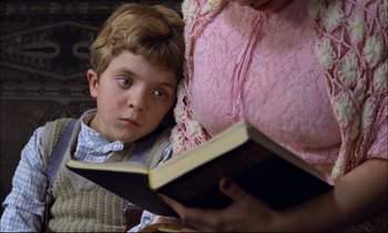 Movie still from “The Tin Drum” (1979), directed by Volker Schlöndorff – A young boy and a woman reading a book together; Close Up shot, Over the shoulder angle