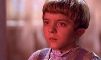 Movie still from “The Tin Drum” (1979), directed by Volker Schlöndorff – A young boy is looking into the distance; Close Up shot, High angle