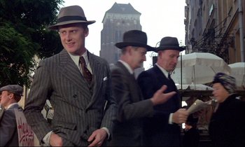 Movie still from “The Tin Drum” (1979), directed by Volker Schlöndorff – A group of men wearing suits and hats; Medium shot, Low angle
