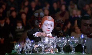 Movie still from “The Tin Drum” (1979), directed by Volker Schlöndorff – A man with a clown face painting on his face; Medium shot, High angle