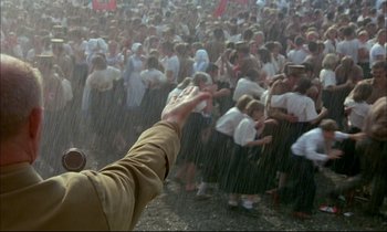 Movie still from “The Tin Drum” (1979), directed by Volker Schlöndorff – A crowd of people standing in the pouring rain; Wide shot, High angle