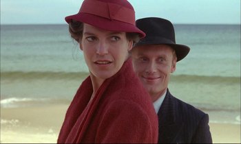 Movie still from “The Tin Drum” (1979), directed by Volker Schlöndorff – A man and a woman wearing hats on the beach; Close Up shot, Over the shoulder angle