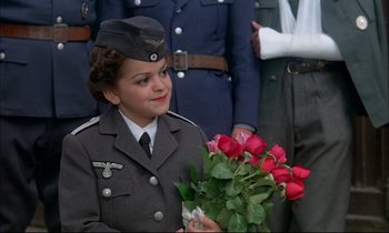 Movie still from “The Tin Drum” (1979), directed by Volker Schlöndorff – A woman in uniform holding a bouquet of roses; Close Up shot, High angle