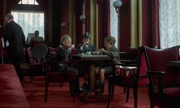 Movie still from “The Tin Drum” (1979), directed by Volker Schlöndorff – A group of young children sitting at a table; Wide shot, High angle